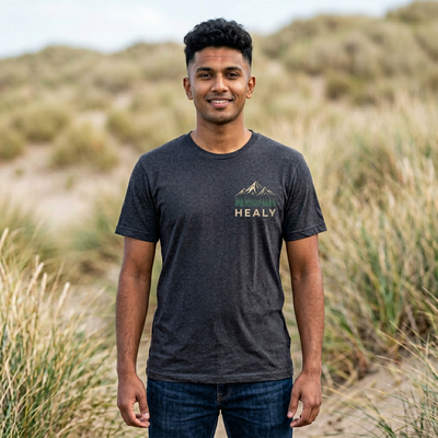 Soft jersey t-shirt with a detailed Healy Alaska mountain and spruce illustration in earthy tones by Evernorth — close-up