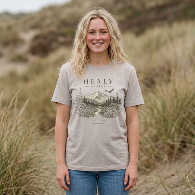 Wilderness t-shirt with an intricate Healy Alaska mountain landscape framed by wildflowers and evergreens by Evernorth — on model