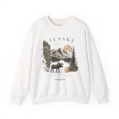 Soft crewneck sweatshirt with a muted Alaska mountain, lake, evergreen and moose illustration by Evernorth — on model
